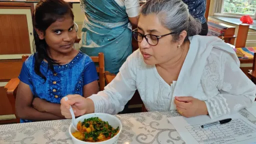 Nita trying a dish with the participant